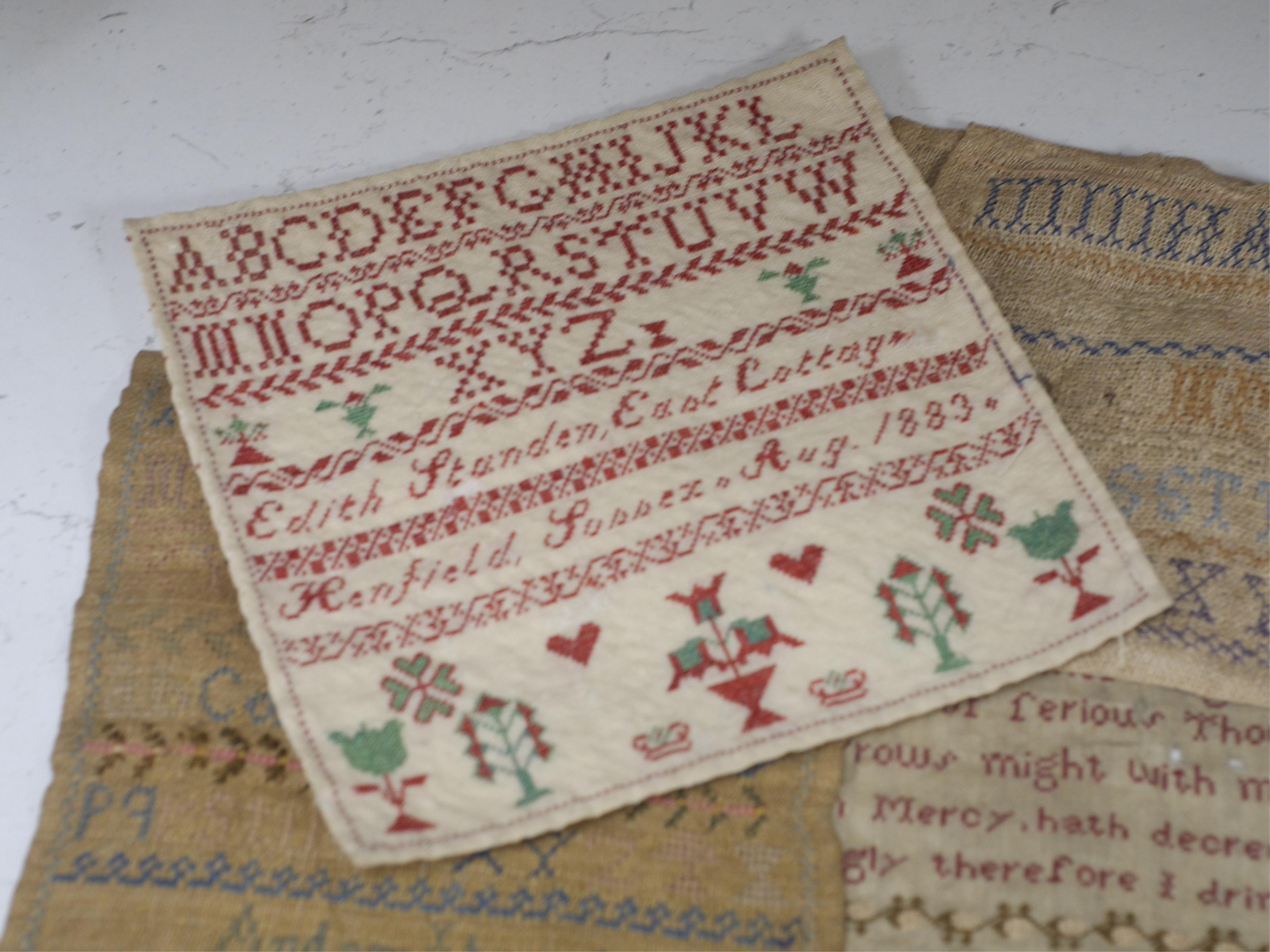 A collection of four 19th century cross stitch alphabet samplers and a larger earlier sampler embroidered by Elizabeth Sizmur aged 11 dated 1795, designed with spot motifs and religious verse. 18th century sampler 42cm x